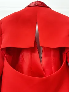 Primo piano del blazer rosso con elegante apertura sulla schiena e strass rossi.