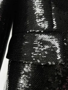 Macro view showing the detailed texture of shimmering black sequins on a blazer pocket.