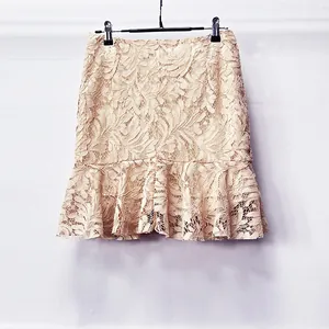 Elegante textura de encaje beige y detalle de dobladillo con volantes de minifalda chic
