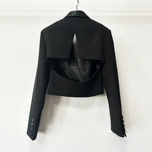 Vista dettagliata del design senza schiena e del colletto con strass su blazer nero.