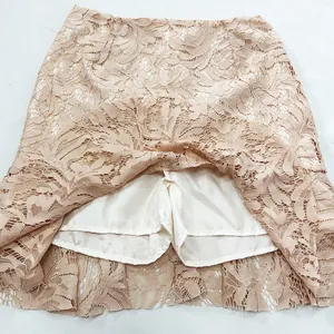 Vista detallada que muestra el pantalón corto interior blanco de una falda de encaje albaricoque