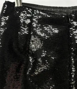Macro view showing the dense shimmering black sequins and zipper detail on fashion shorts