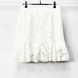 Vista detallada de la elegante tela de encaje floral blanco en una falda con volantes
