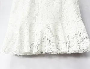 Primer plano que muestra la textura de encaje floral y el dobladillo con volantes de esta falda.