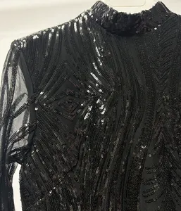 Nahaufnahme der aufwendigen schwarzen Paillettenmuster auf Netzstoff am Abendkleid