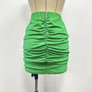 Detailed back view of a green ruched elastic knit mini skirt with rhinestone accents
