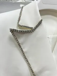 Detail shot of elegant white blazer dress with sparkling silver rhinestone trim