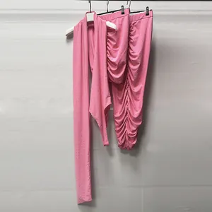 Detailed macro view of pink two-piece knit set with rhinestones and ruched skirt