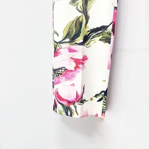 Macro detail shot of white trousers featuring pink peony floral print for high-end suit set