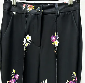 Close-up detail of high-waisted black floral suit pants featuring elegant flower patterns