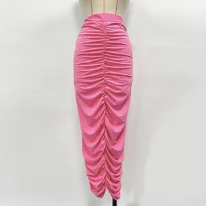 Detail of pink knitted midi skirt featuring elegant ruching and sparkling rhinestones.