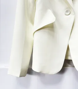 Detailed close-up of ivory white elegant tailored blazer showing premium fabric texture