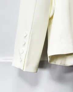 High-quality close-up detail of an off-white blazer sleeve cuff with four elegant buttons