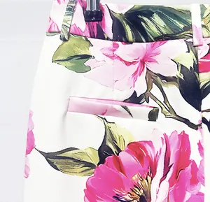 Macro detail of the vibrant pink floral print and welt pocket on slim-fit trousers.