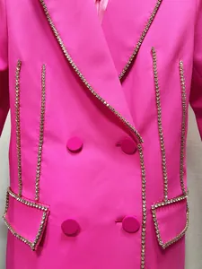 Detail shot of a hot pink blazer dress featuring luxury sparkling rhinestone trim.