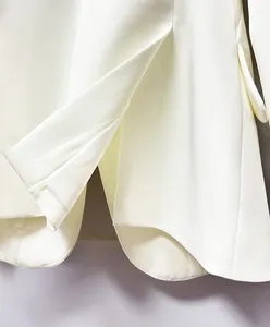 Detailed macro shot of premium white heavy fabric blazer hem with elegant back vent