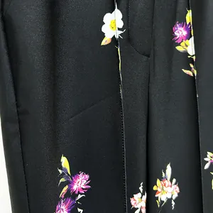 Detailed macro view of high-end black fabric featuring elegant vivid floral patterns