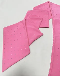 Macro detail view of pink elastic knit fabric decorated with sparkling hot-fix rhinestones