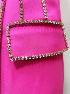 Close-up of sparkling rhinestone trim on the pocket of a hot pink luxury blazer dress.