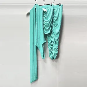 Close-up detail of elegant turquoise rhinestone knit top and ruched midi skirt set