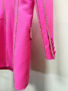 Close-up detail of hot pink blazer dress featuring sparkling rhinestone trim and sleeve buttons