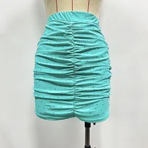 Detailed view of turquoise ruched mini skirt with sparkling rhinestone embellishments