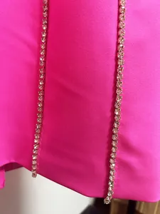 Close-up of hot pink blazer dress showing elegant rhinestone trim and fabric texture