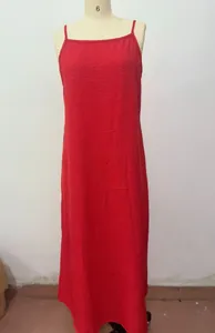 Détail d'une robe longue rouge en coton et lin avec de fines bretelles sur mannequin.