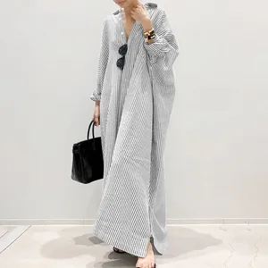 Elegant model wearing a black and white striped oversized maxi shirt dress in detail