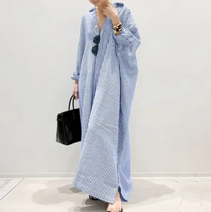 Elegant detail showing oversized blue and white striped long shirt dress with loose fit