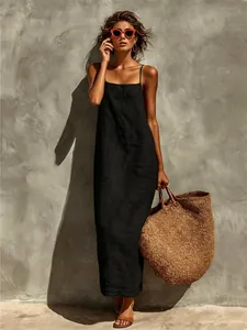 Gros plan d'une robe longue en lin noir chic avec un grand sac fourre-tout en paille.