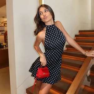 Stylish women's backless polka dot halter mini dress for chic summer cocktail parties.