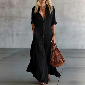 Detail of a chic long black shirt dress with buttons and pockets for elegant women