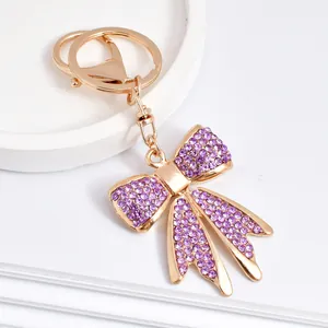 Exquisite detailed macro view of a gold bow keychain encrusted with sparkling purple rhinestones