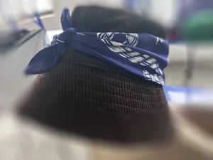 Close-up detail of a blue patterned cotton bandana tied on a brown corduroy bucket hat