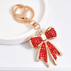 Macro view of a sparkling red rhinestone bowknot keychain with a polished gold finish metal