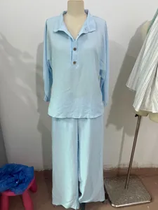 Light blue two-piece women's lounge set featuring button-down top and wide-leg trousers.