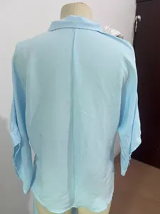 Detail view of the back of a light blue long-sleeved urban commuter blouse on mannequin