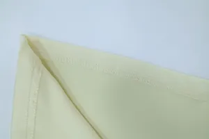 Nahaufnahme der hochwertigen Saumnaht an einem cremefarbenen ärmellosen Abendkleid