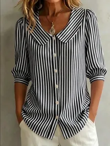 Macro view of a stylish black and white vertical striped blouse with elegant puff sleeves.