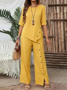 Full view of women's yellow linen set with asymmetrical button top and matching wide-leg pants