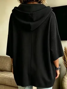 Vista posterior detallada de una sudadera con capucha negra de punto gofrado