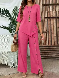 Elegant pink two-piece set for women featuring irregular hem top and button-up wide pants.