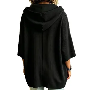 Vista posterior de una sudadera con capucha oversize negra de punto gofre para mujer.