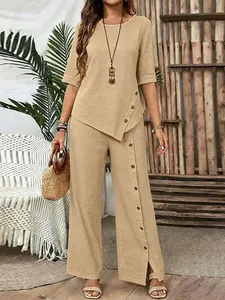Elegant beige two-piece linen set with irregular hem shirt and wide-leg button trousers.