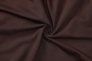 Macro view of soft dark brown ribbed knit fabric with elegant swirl draping texture details