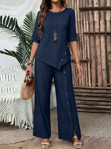 Elegante completo due pezzi blu navy con top a orlo irregolare e pantaloni larghi con bottoni.