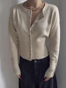 Detalle de un cárdigan de punto crema con cuello redondo y diseño de talle alto acanalado