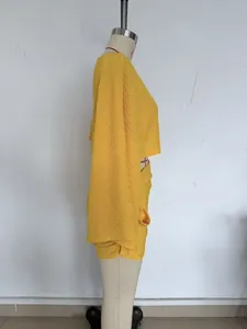 Vue latérale d'un ensemble deux pièces jaune texturé avec haut court et mini-jupe.