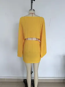 Vue arrière de l'ensemble haut à manches longues et mini-jupe jaune à texture gaufrée
